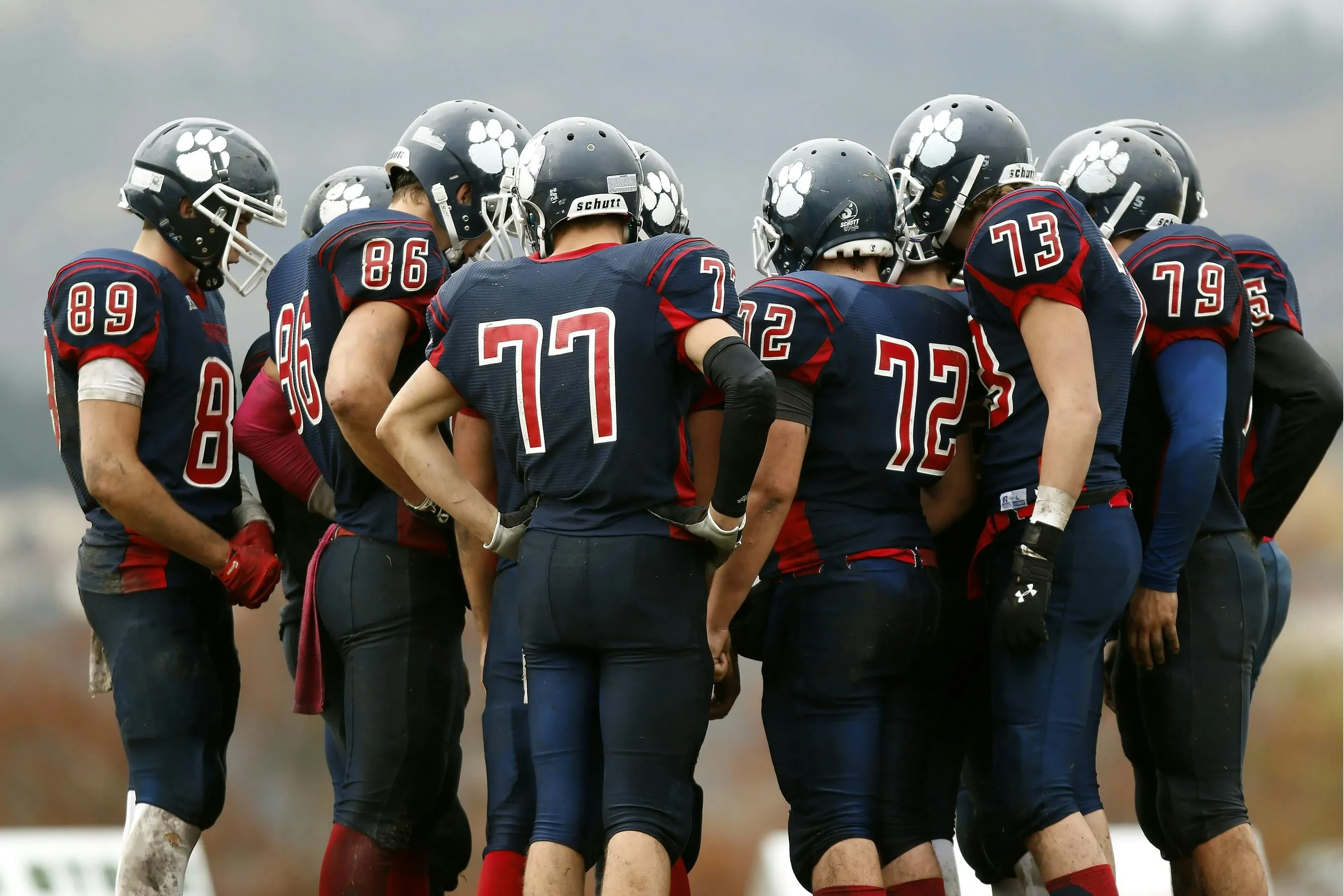 A group of football players in a huddle, ready for mental training for today via the Focus 5 app.